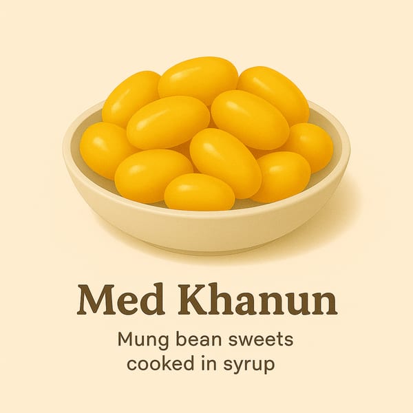 A bowl of bright yellow, oval-shaped Med Khanun, mung bean sweets cooked in syrup.